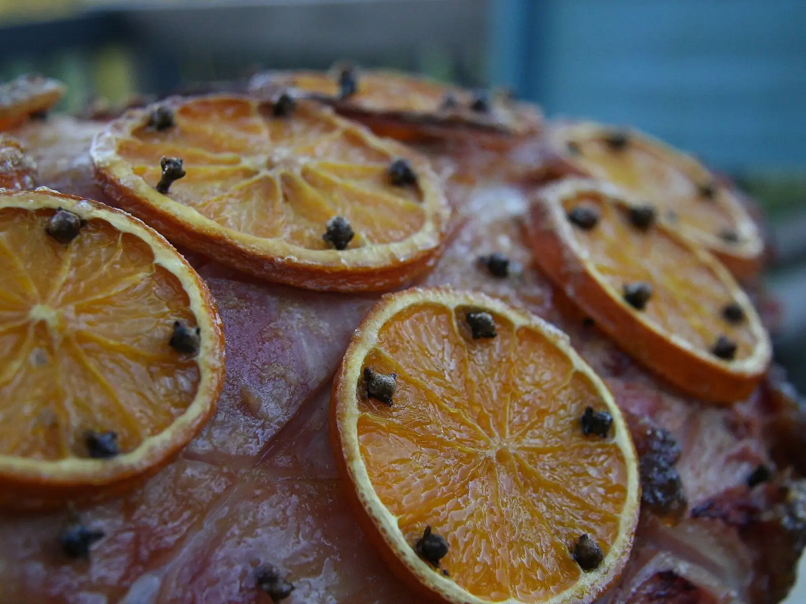A cooked ham glazed and studded with cloves, topped with orange slices, ready for Christmas.